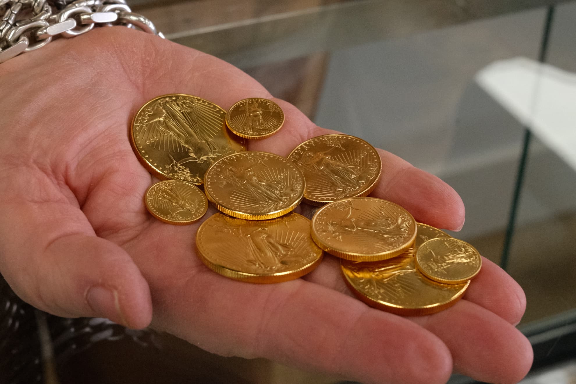 American Gold Eagle coins held in hand — we buy and sell gold coins in Rogers, Arkansas