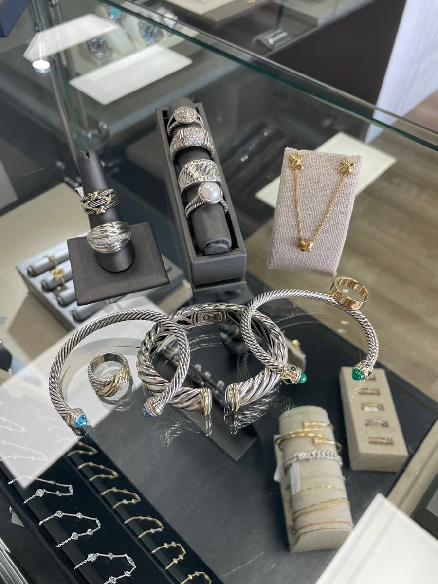 Estate jewelry display case at Gold & Diamond Company in Rogers, Arkansas — silver cable bracelets, vintage rings, and earrings